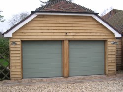 Metallic grey steel sectional garage door installed on timber framework