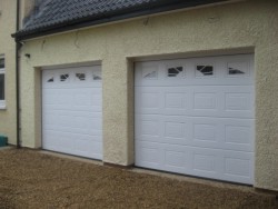White panelled sectional garage door with sunburst style windows available as an optional extra