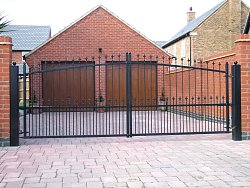Simple design black painted steel side hinged gates with FAAC automation. 