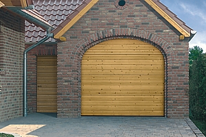 Natural timber sectional garage door installed on brickwork opening with matching side entrance door