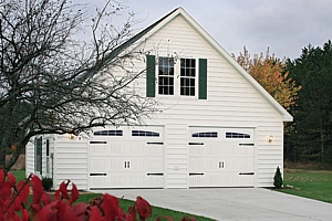 Classic style sectional garage doors in white with immitation brackets and windows