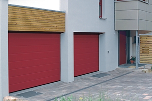 Red sectional garage doors installed on a concrete opening