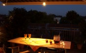 Retractable patio awning at night with adjustable lighting over dining table