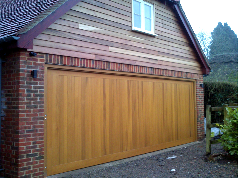 Cedar Bakewell Cedar wood timber door installed inbetween double brick garage with cedar clad sub frame