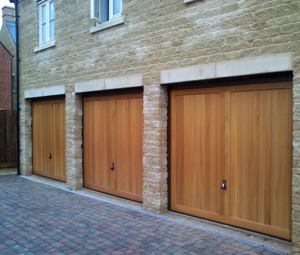Hormann 2013 Caxton Cedar wood timber doors installed behind triple stone garage