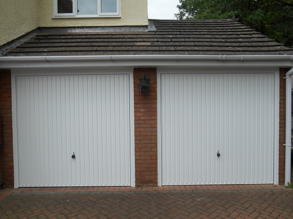 Twin Hormann 2001 vertical ribbed steel up and over doors in white.
