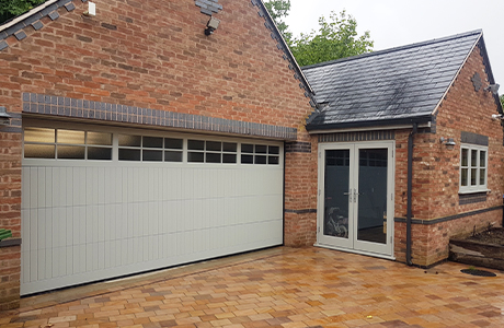 timber sectional door with traditional windows and a heritage colour finish
