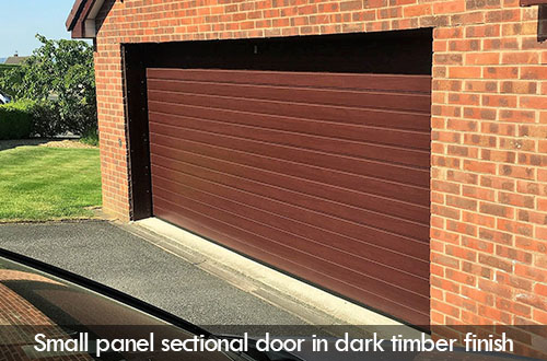small panel sectional door in dark timber finish stronghaus