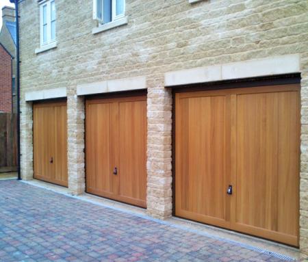 Hormann 2013 Caxton Cedar wood timber doors installed behind triple stone garage