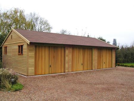 Three Hormann 2009 Vertical Cedar wood timber doors installed behind openings on triple detached timber garage